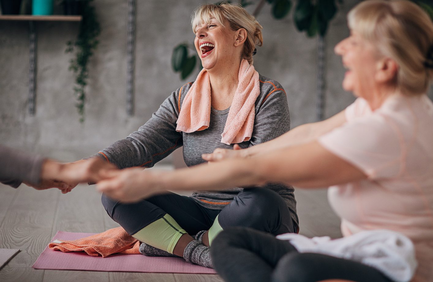 Zwei Frauen beim Rehasport im ellevital – lachend beim Dehnen auf der Matte